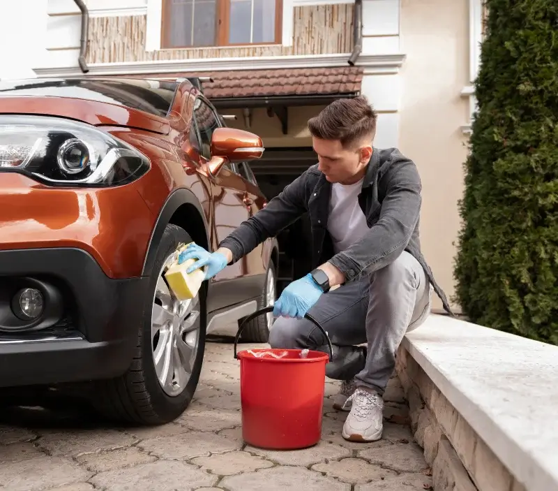Lavage auto à domicile Conches-sur-Gondoire : professionnel intervenant sur un véhicule
